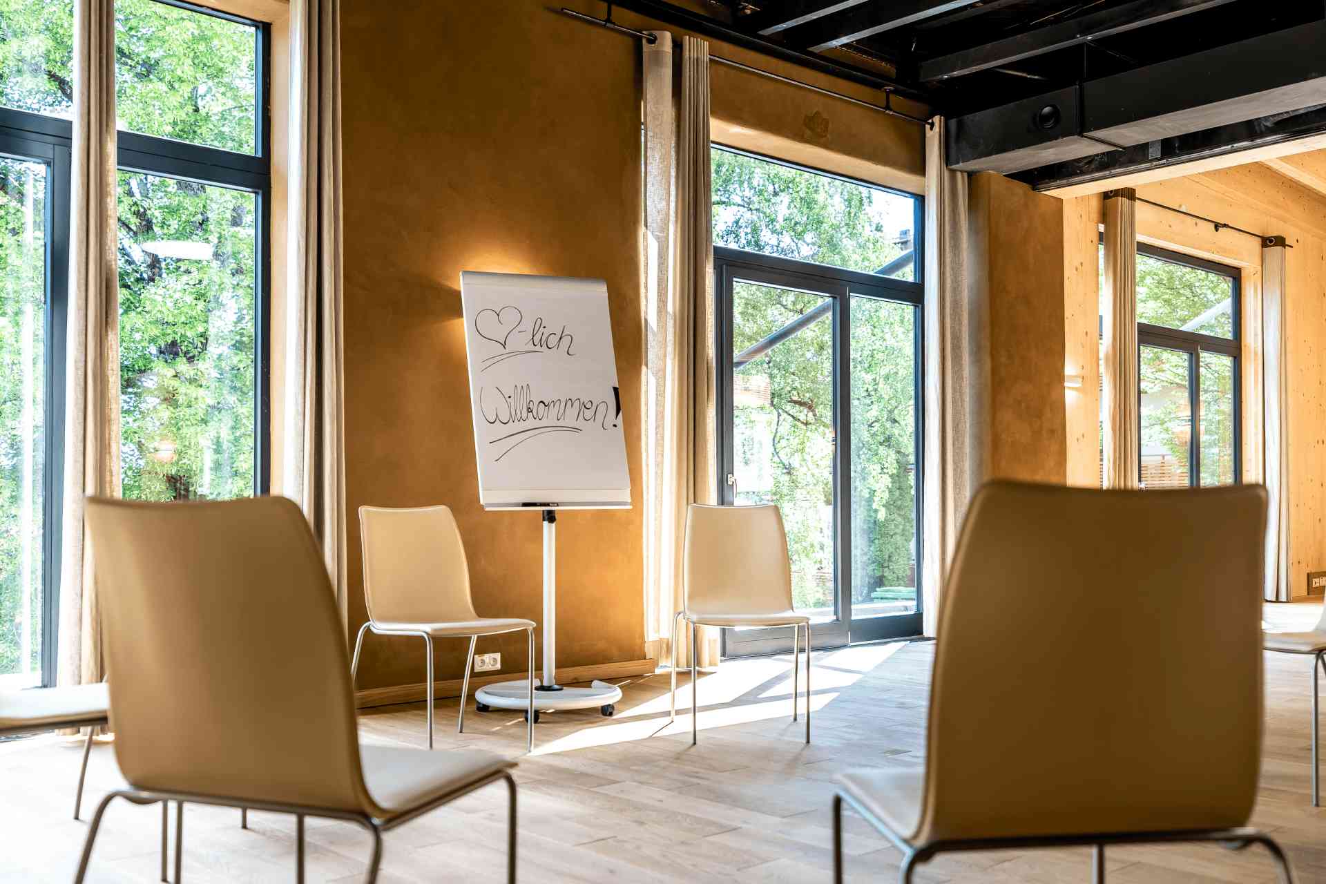 Seminarraum mit Stuhlkreis, Flipchart und Blick ins Grüne